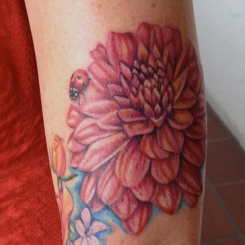 Dahlia flower tattoo done on the inner forearm