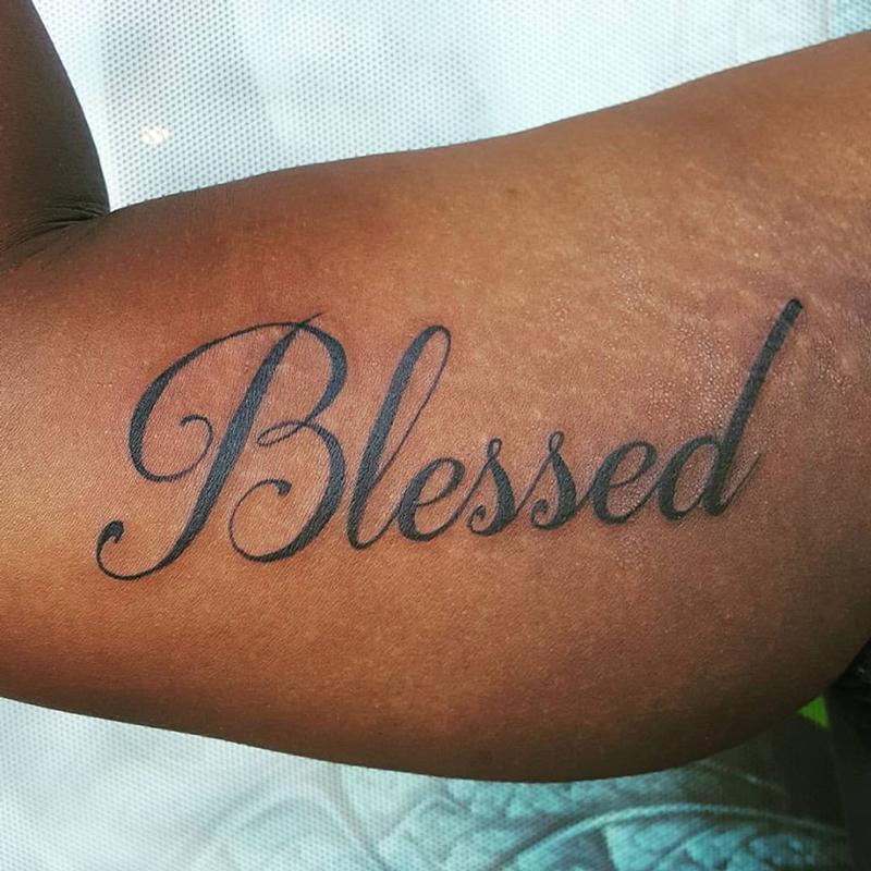 Black simple blessed tattoo on back waistline by Blindsidecustoms