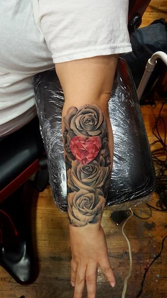 Dragon and roses tattoo located on the upper arm